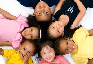 Smiling children laying in a circle